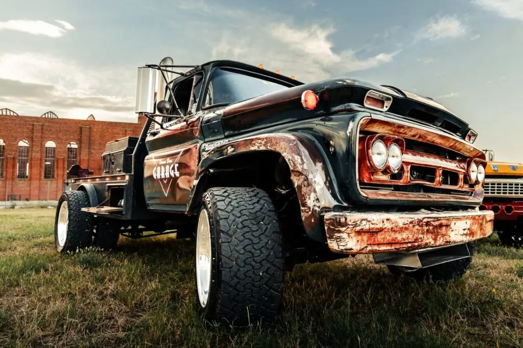 Weathered black Chevrolet diesel truck photographed from a low angle