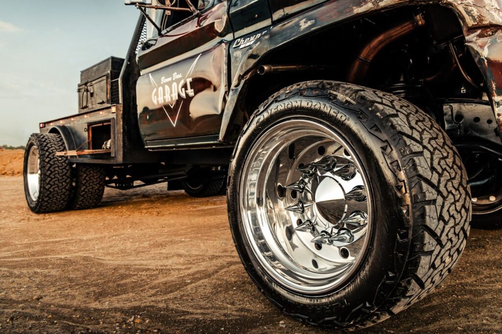 Detail of an all-terrain tire and polished dually wheel on a black diesel truck