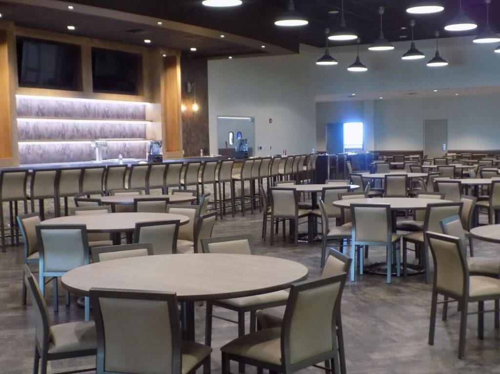 The VIP lounge with round tables, a bar and windows overlooking the arena
